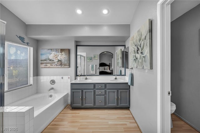818 Grape Vine Ave, Henderson, NV 89002 - full bathroom with double vanity, a garden tub, wood finished floors, and recessed lighting