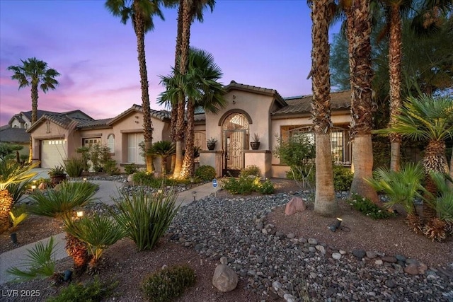 10674 Chillingham Dr, Las Vegas, NV 89183 - mediterranean / spanish-style home featuring an attached garage, stucco siding, a tile roof, and concrete driveway