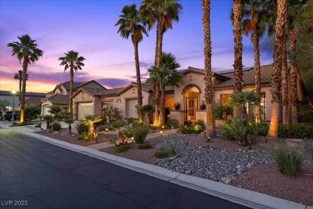10674 Chillingham Dr, Las Vegas, NV 89183 - mediterranean / spanish-style home featuring stucco siding, an attached garage, a tiled roof, and solar panels