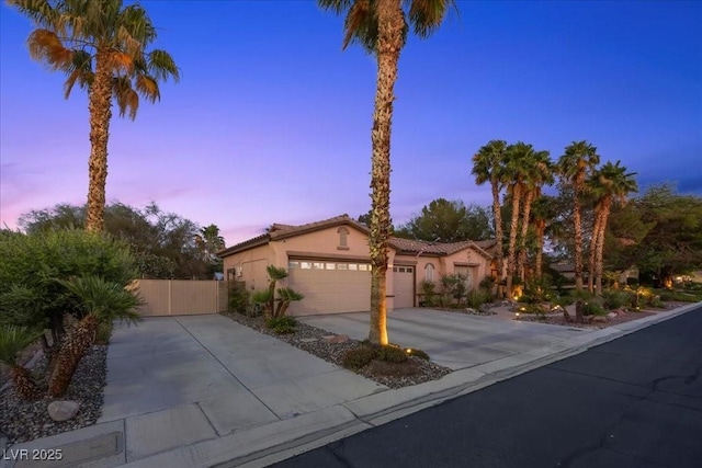 10674 Chillingham Dr, Las Vegas, NV 89183 - mediterranean / spanish-style house with stucco siding, concrete driveway, a garage, and a tiled roof