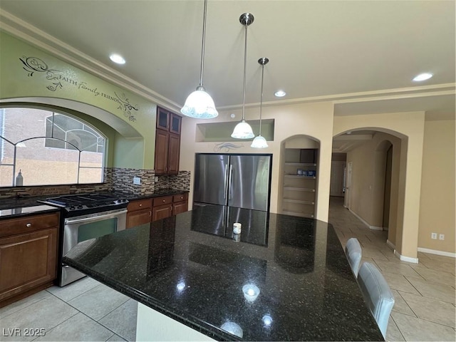 6277 Mustang Spring Ave, Las Vegas, NV 89139 - kitchen featuring stainless steel appliances, light tile patterned floors, arched walkways, a spacious island, and ornamental molding