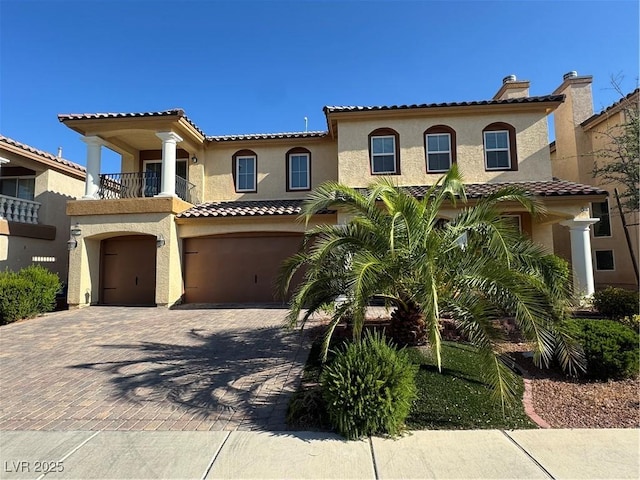 6277 Mustang Spring Ave, Las Vegas, NV 89139 - mediterranean / spanish house with an attached garage, stucco siding, decorative driveway, a balcony, and a tile roof