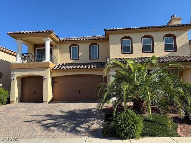 6277 Mustang Spring Ave, Las Vegas, NV 89139 - mediterranean / spanish-style house with an attached garage, a balcony, stucco siding, and decorative driveway
