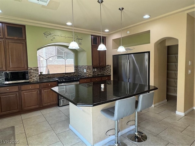 6277 Mustang Spring Ave, Las Vegas, NV 89139 - kitchen with stainless steel appliances, arched walkways, backsplash, crown molding, and light tile patterned floors