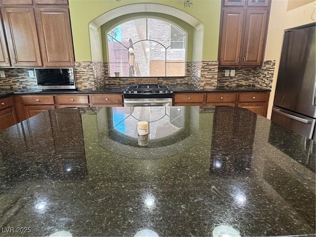 6277 Mustang Spring Ave, Las Vegas, NV 89139 - kitchen featuring stainless steel appliances, tasteful backsplash, glass insert cabinets, and dark stone countertops