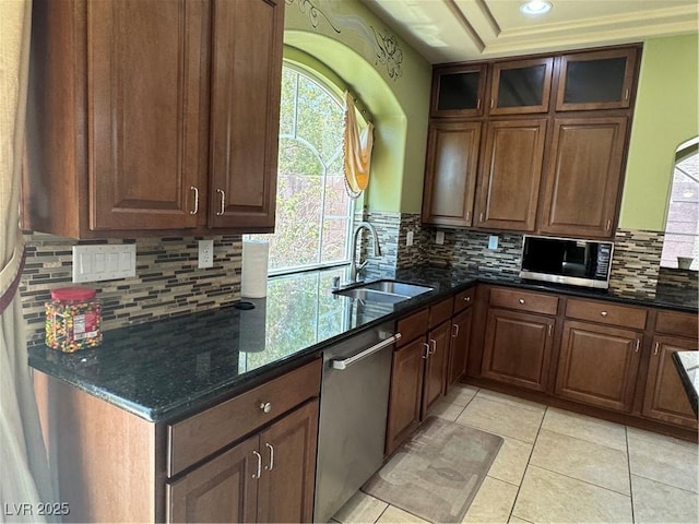 6277 Mustang Spring Ave, Las Vegas, NV 89139 - kitchen with appliances with stainless steel finishes, dark stone countertops, decorative backsplash, light tile patterned floors, and glass insert cabinets
