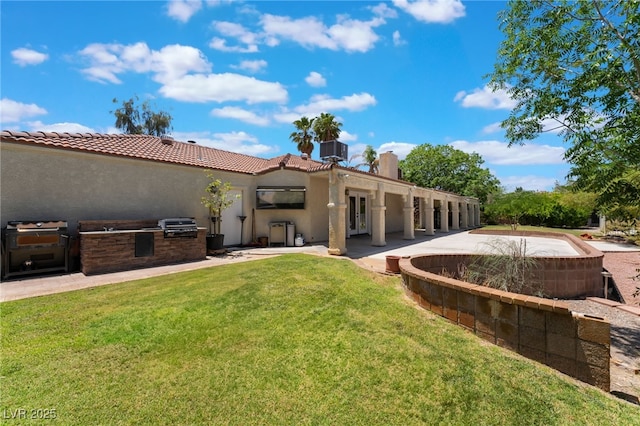 4530 W Shelbourne Ave, Las Vegas, NV 89139 - back of house with an outdoor kitchen, stucco siding, a yard, and a chimney