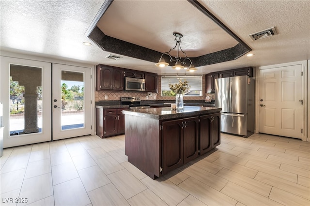4530 W Shelbourne Ave, Las Vegas, NV 89139 - kitchen with stainless steel appliances, a textured ceiling, dark countertops, healthy amount of natural light, and dark brown cabinets