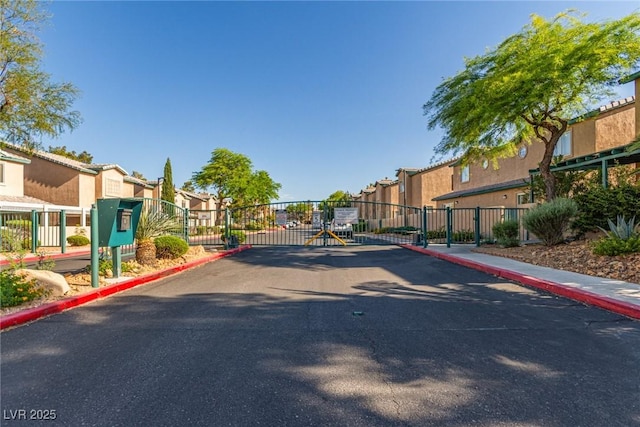 5249 Wave Dancer Ln, Las Vegas, NV 89118 - view of asphalt street featuring a residential view, a gate, curbs, and a gated entry