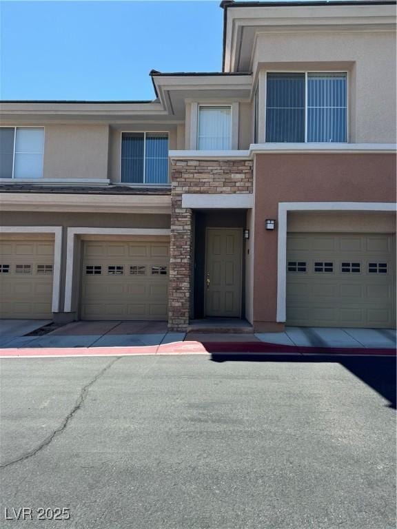 656 Peachy Canyon Cir Unit 203, Las Vegas, NV 89144 - property entrance featuring a garage, stucco siding, and stone siding