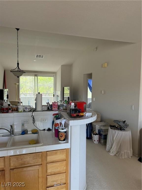 656 Peachy Canyon Cir Unit 203, Las Vegas, NV 89144 - kitchen featuring carpet, light countertops, vaulted ceiling, and hanging light fixtures