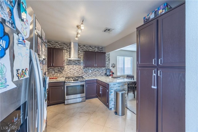 433 Jubilation Dr, Las Vegas, NV 89145 - kitchen with stainless steel appliances, wall chimney exhaust hood, a peninsula, decorative backsplash, and light stone counters