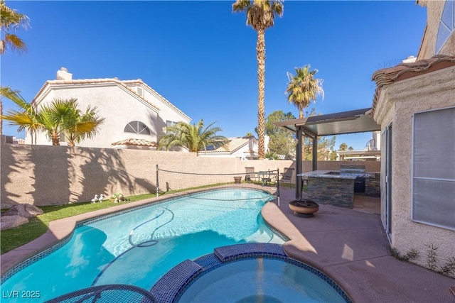 433 Jubilation Dr, Las Vegas, NV 89145 - view of pool featuring exterior kitchen, a pool with connected hot tub, a fenced backyard, and a patio area