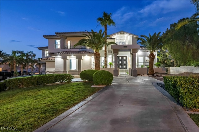 2058 Troon Dr, Henderson, NV 89074 - mediterranean / spanish-style house with stucco siding, a front yard, a gate, a tile roof, and a balcony