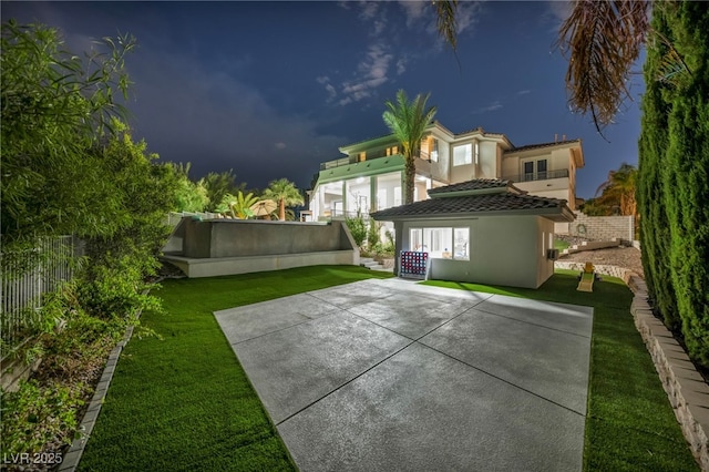 2058 Troon Dr, Henderson, NV 89074 - back of house at twilight featuring stucco siding, a tile roof, and a patio area