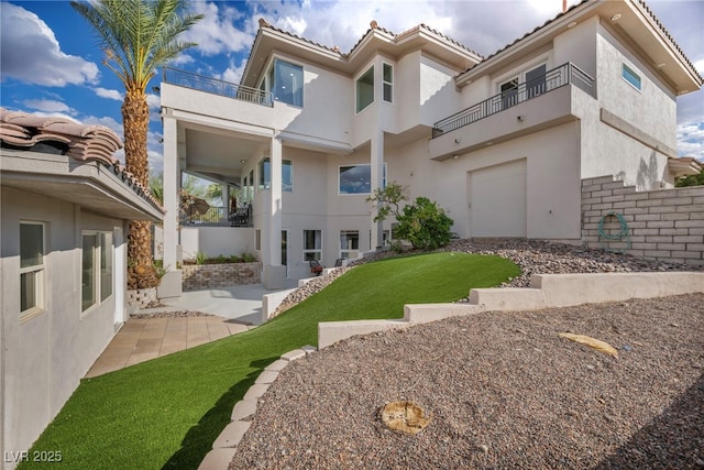2058 Troon Dr, Henderson, NV 89074 - back of property featuring a balcony, stucco siding, a lawn, and a tiled roof