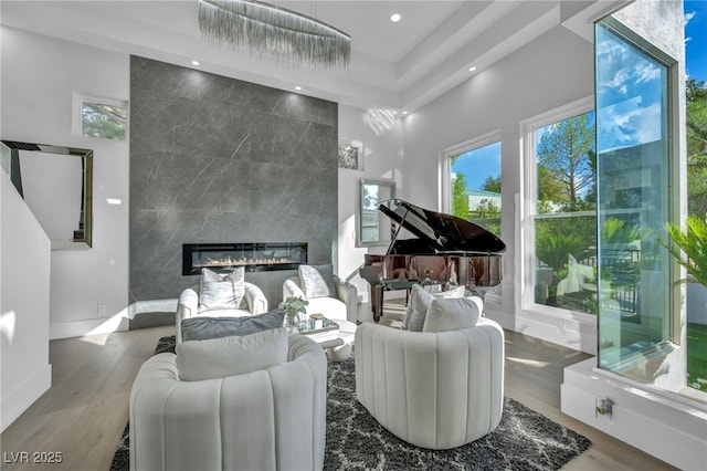 2058 Troon Dr, Henderson, NV 89074 - living area featuring healthy amount of natural light, recessed lighting, wood finished floors, a premium fireplace, and a high ceiling