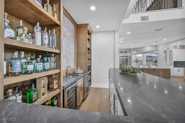2058 Troon Dr, Henderson, NV 89074 - indoor wet bar featuring wine cooler, light wood finished floors, recessed lighting, built in fridge, and pendant lighting