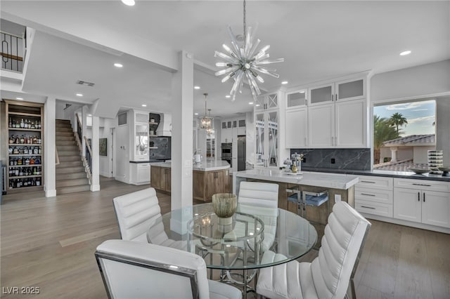 2058 Troon Dr, Henderson, NV 89074 - dining area with a chandelier, light wood-type flooring, recessed lighting, and stairs