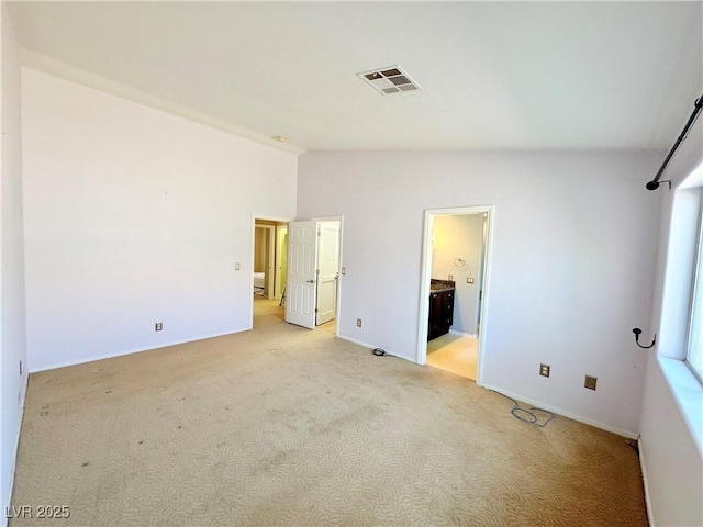 3523 Calf Roper Ct, North Las Vegas, NV 89032 - unfurnished bedroom with lofted ceiling, light colored carpet, and ensuite bathroom