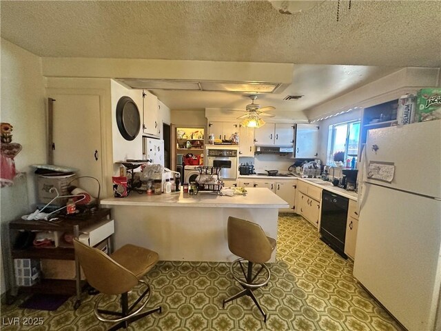 3505 W Bonanza Rd, Las Vegas, NV 89107 - kitchen featuring white appliances, a peninsula, light countertops, ceiling fan, and under cabinet range hood