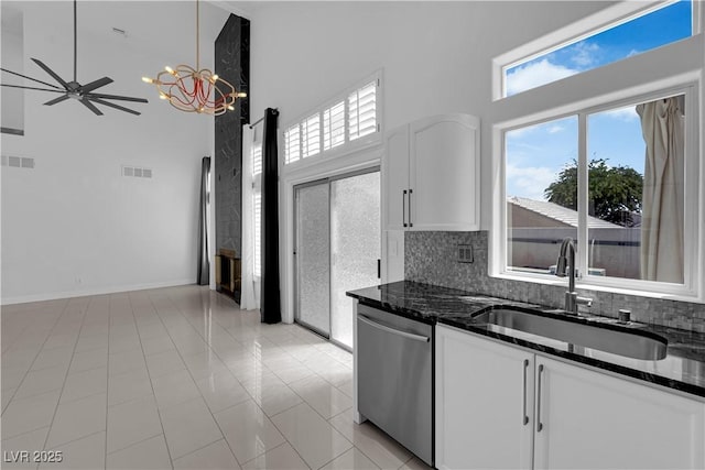 4604 Barnes Ct, Las Vegas, NV 89147 - kitchen with dishwasher, a towering ceiling, white cabinets, dark stone countertops, and a ceiling fan