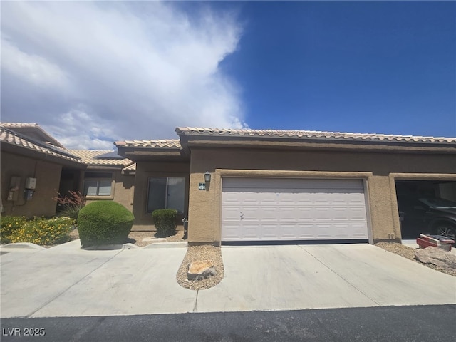 4764 Wild Draw Dr, North Las Vegas, NV 89031 - view of front facade featuring driveway, a tile roof, an attached garage, and stucco siding