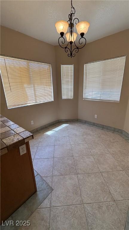 1081 Overture Dr, Las Vegas, NV 89123 - unfurnished dining area with a chandelier and light tile patterned flooring