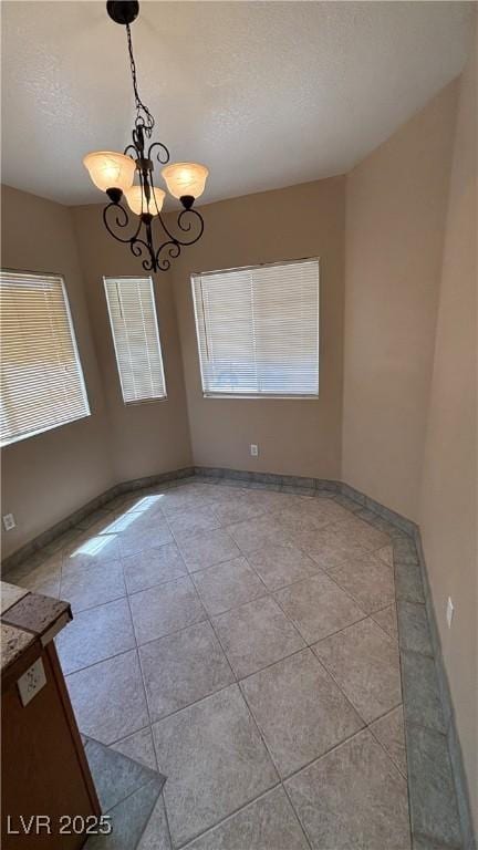 1081 Overture Dr, Las Vegas, NV 89123 - unfurnished room with healthy amount of natural light, a chandelier, light tile patterned floors, and a textured ceiling
