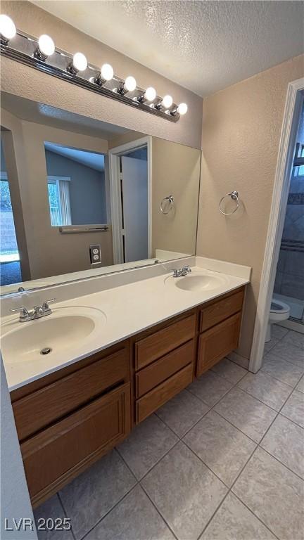 1081 Overture Dr, Las Vegas, NV 89123 - full bath with a textured ceiling, double vanity, and tile patterned flooring