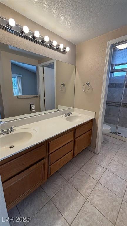 1081 Overture Dr, Las Vegas, NV 89123 - full bath featuring a textured ceiling, double vanity, a stall shower, and tile patterned floors
