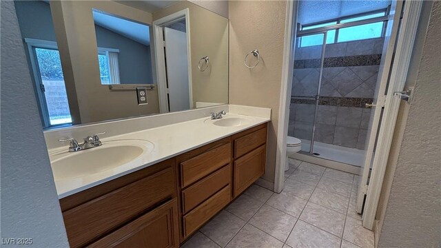 1081 Overture Dr, Las Vegas, NV 89123 - full bath featuring a textured wall, plenty of natural light, a shower stall, double vanity, and tile patterned floors