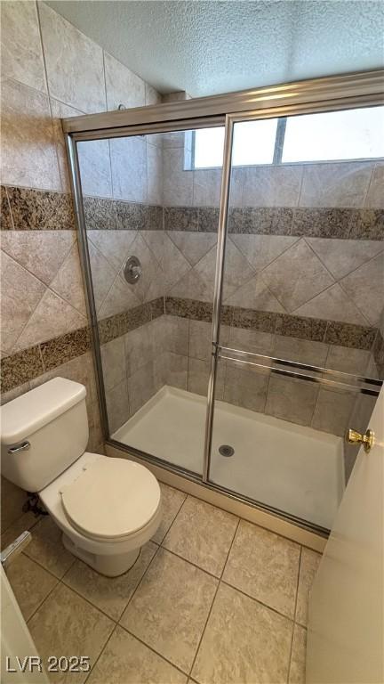 1081 Overture Dr, Las Vegas, NV 89123 - bathroom with plenty of natural light, a stall shower, tile patterned floors, and a textured ceiling