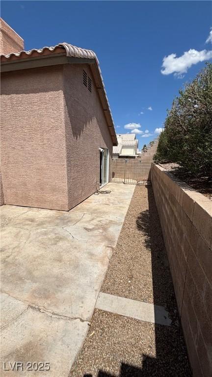 1081 Overture Dr, Las Vegas, NV 89123 - view of side of property with a patio, stucco siding, and a fenced backyard