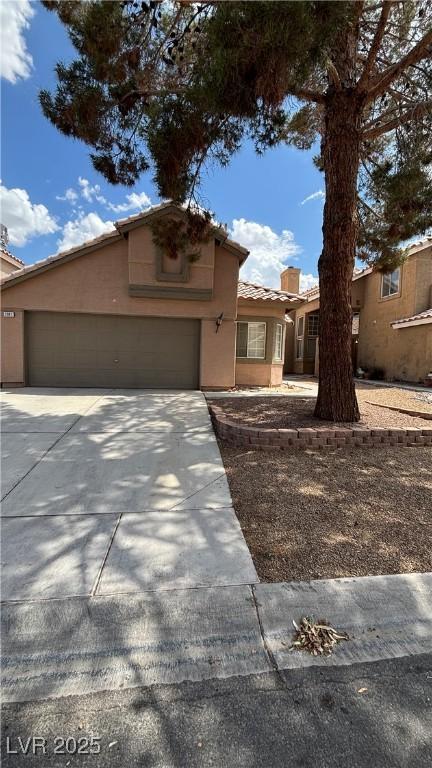 1081 Overture Dr, Las Vegas, NV 89123 - view of front of property featuring driveway, a tile roof, stucco siding, and an attached garage