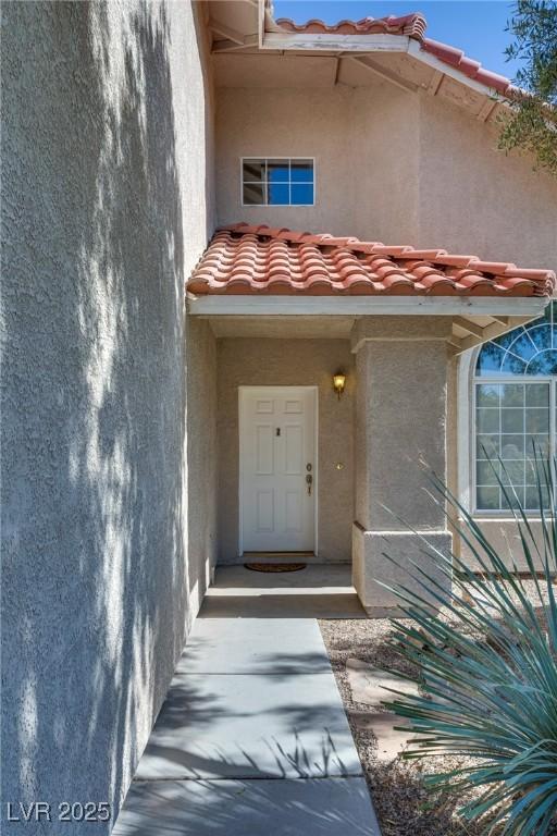 8771 Martinique Bay Ln, Las Vegas, NV 89147 - doorway to property featuring a tiled roof and stucco siding