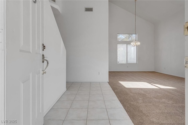 8771 Martinique Bay Ln, Las Vegas, NV 89147 - foyer entrance featuring high vaulted ceiling, light tile patterned flooring, light colored carpet, and a chandelier