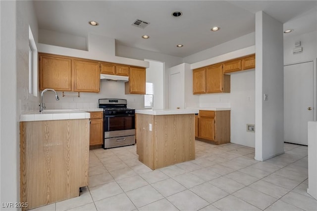 8771 Martinique Bay Ln, Las Vegas, NV 89147 - kitchen featuring gas stove, under cabinet range hood, a center island, recessed lighting, and light tile patterned floors