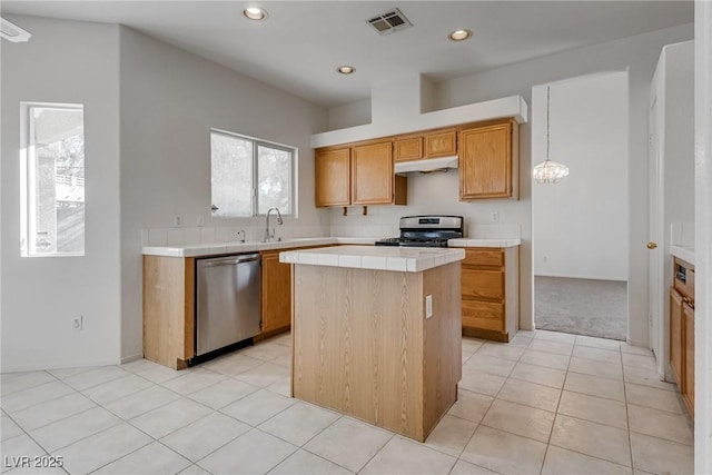 8771 Martinique Bay Ln, Las Vegas, NV 89147 - kitchen with appliances with stainless steel finishes, tile counters, under cabinet range hood, a center island, and recessed lighting