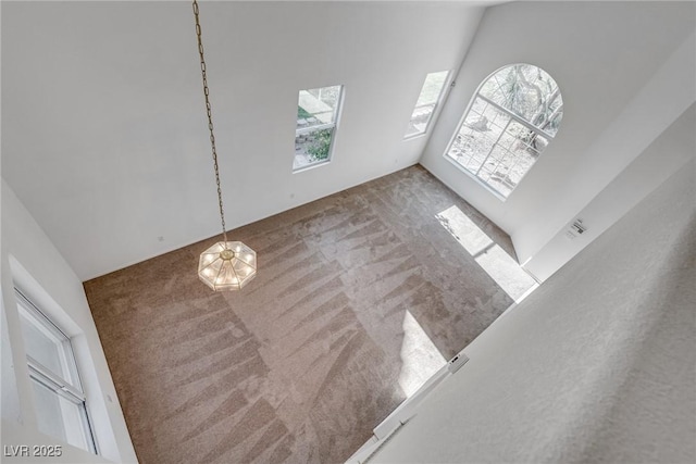 8771 Martinique Bay Ln, Las Vegas, NV 89147 - unfurnished living room featuring carpet flooring and a towering ceiling