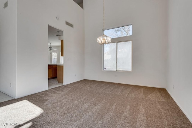 8771 Martinique Bay Ln, Las Vegas, NV 89147 - carpeted spare room featuring a chandelier, a towering ceiling, and a ceiling fan