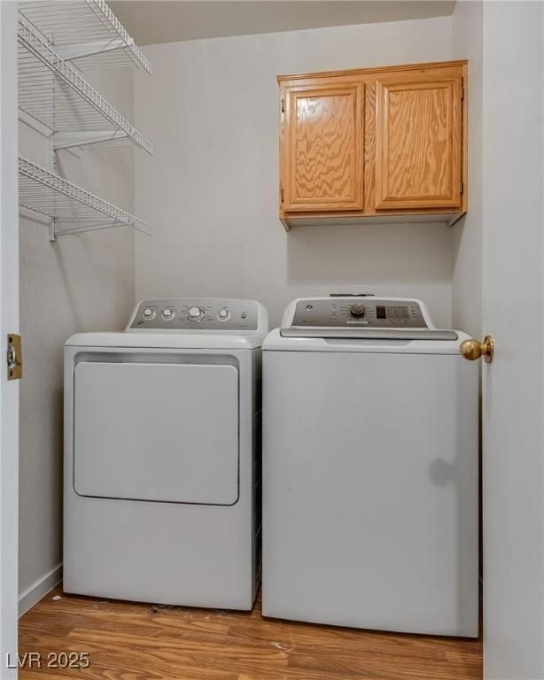 8771 Martinique Bay Ln, Las Vegas, NV 89147 - washroom with separate washer and dryer, light wood-type flooring, and cabinet space