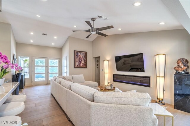 3101 Hayden Ct, Las Vegas, NV 89134 - living area with a ceiling fan, light wood-style floors, recessed lighting, vaulted ceiling, and a glass covered fireplace