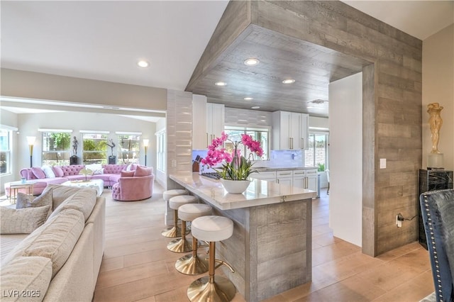 3101 Hayden Ct, Las Vegas, NV 89134 - kitchen featuring open floor plan, white cabinets, a kitchen bar, light countertops, and recessed lighting