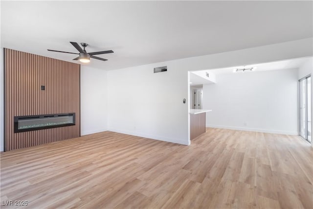 3459 One Nation Ave, Las Vegas, NV 89121 - unfurnished living room with a glass covered fireplace, a ceiling fan, and light wood-style floors