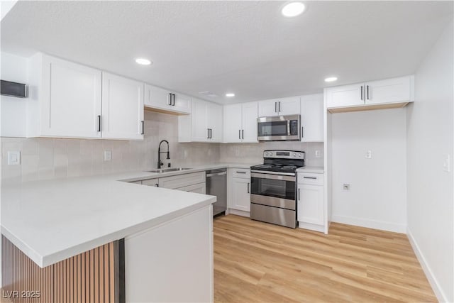 3459 One Nation Ave, Las Vegas, NV 89121 - kitchen featuring appliances with stainless steel finishes, light countertops, a peninsula, decorative backsplash, and recessed lighting