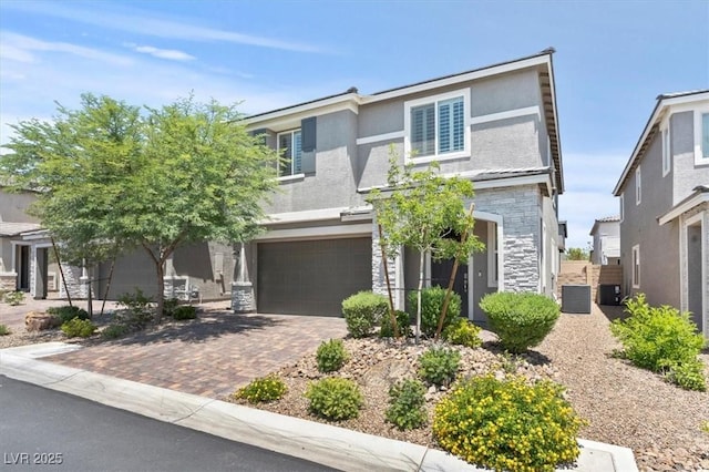 7456 Tinley Creek Ave, Las Vegas, NV 89113 - view of front of home with stone siding, a garage, decorative driveway, and stucco siding