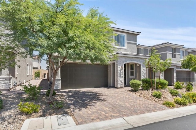 7456 Tinley Creek Ave, Las Vegas, NV 89113 - view of front facade featuring stone siding, decorative driveway, an attached garage, and stucco siding