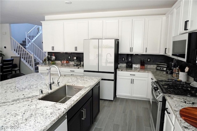 8131 Skye Plum St, Las Vegas, NV 89166 - kitchen with stainless steel appliances, white cabinetry, backsplash, and light stone countertops