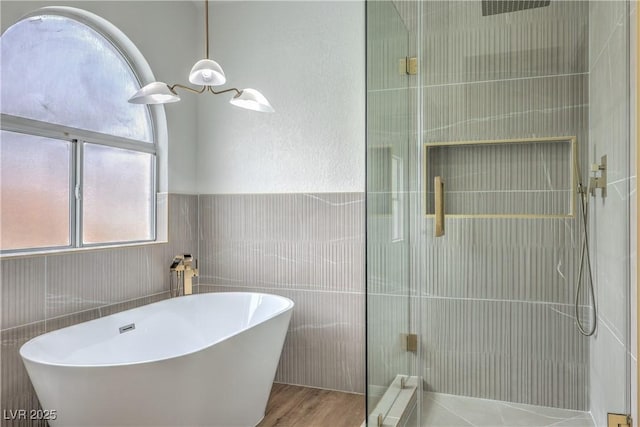 2107 Fountain Springs Dr, Henderson, NV 89074 - bathroom with a stall shower, radiator heating unit, a soaking tub, tile walls, and wood finished floors